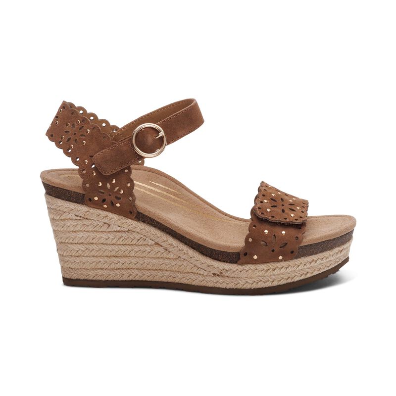 The Aetrex Women's Sydney Scotch Cutout wedge sandal by AETREX WORLDWide INC features a brown braided jute platform, perforated ankle and toe straps, a round metal buckle, and an arch-supporting cushioned footbed ideal for plantar fasciitis.