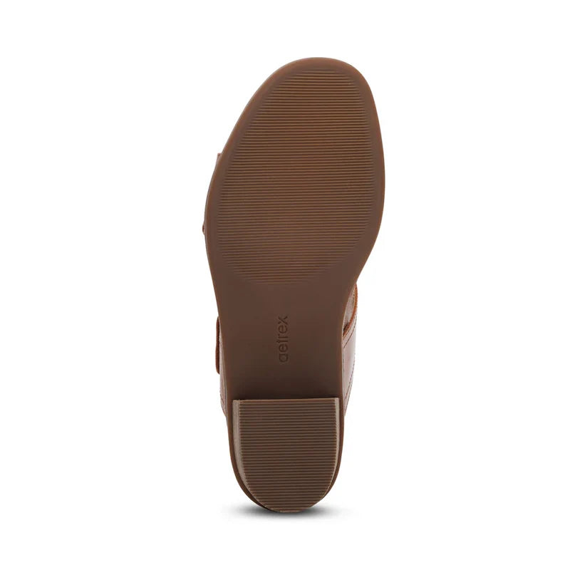 The image displays the brown sole of the Aetrex Womens Tatiana Cognac shoe by AETREX WORLDWide INC, featuring horizontal grooves for traction and aetrex embossed near the heel, designed to support foot pain relief.