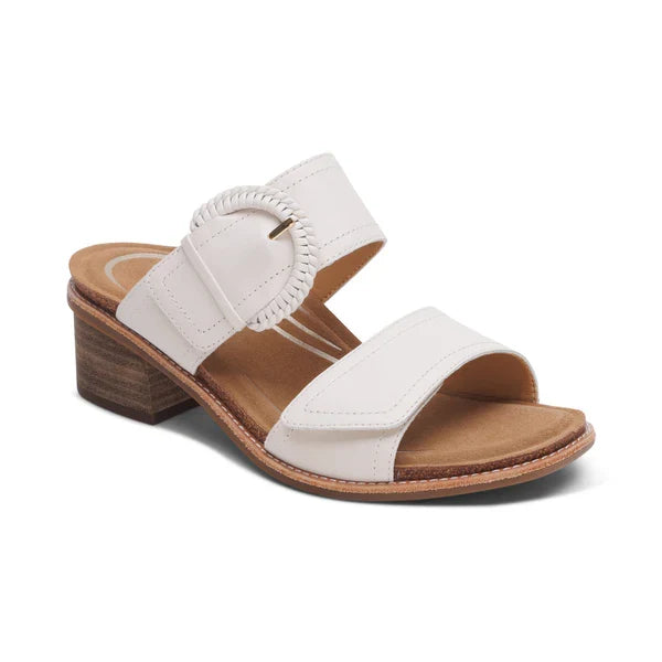 AETREX WORLDWide INC's Aetrex Women's Tatiana Ivory is a white open-toe sandal with two straps, a circular buckle, a low wooden block heel, and a tan insole—ideal for comfortable wear or plantar fasciitis support.
