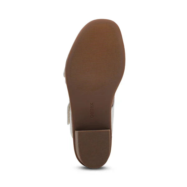 The image shows the bottom view of the Aetrex Women's Tatiana Ivory by AETREX WORLDWide INC, featuring a brown sole, low block heel, fine horizontal tread lines, and "aetrex" near the arch—ideal for comfortable wear or plantar fasciitis relief.