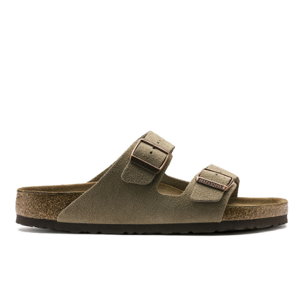 A side view of the BIRKENSTOCK Mens Arizona Soft Footbed sandal in taupe suede, featuring two adjustable top straps with large metal buckles, a cork footbed, and a dark textured sole.