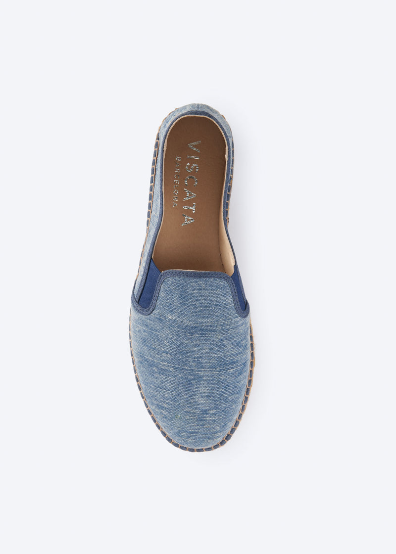 Top view of washed denim espadrille flat with side gore detail and a natural braided jute platform sole, handcrafted in Spain