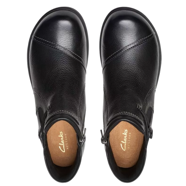 Top view of Clarks Women's Certina Joy Wide Black boots—sleek black leather ankle boots with side zippers, tan insoles, and gold CLARKS branding. Stylish and comfortable footwear for any occasion.