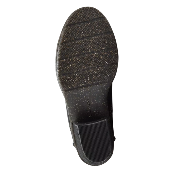 The image displays the bottom view of the Clarks Women's Kastela Lo Black Leather boot by CLARKS, featuring a textured black rubber sole with horizontal grooves, a rectangular heel section, and visible worn speckled patterns.