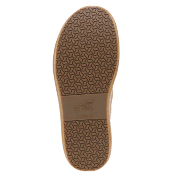 The image shows the sole of the Dansko Women's Honey Pro Cloud / Honey clog by DANSKO, featuring a textured geometric tread pattern and embossed logo in the center, highlighting its slip-resistant outsole.