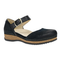 The Dansko Womens Mae Black Suede by DANSKO features a closed-toe black suede Mary Jane design with an ankle strap and buckle, cushioned beige insole for comfort, and a low brown wedge heel with visible stitching on the sole.