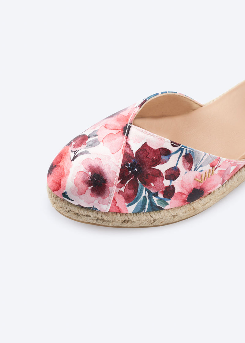 Close-up of floral print espadrille with crossed vamp and a natural braided jute sole, handcrafted in Spain