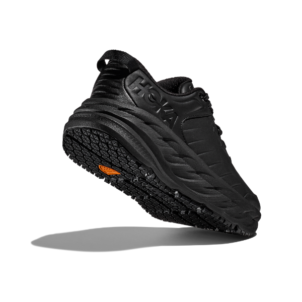 The HOKA Mens Bondi SR Wide in black features a thick, textured sole with a small orange logo underneath. Shown mid-air against a white background, this cushioned sneaker offers a slip-resistant outsole for extra stability.