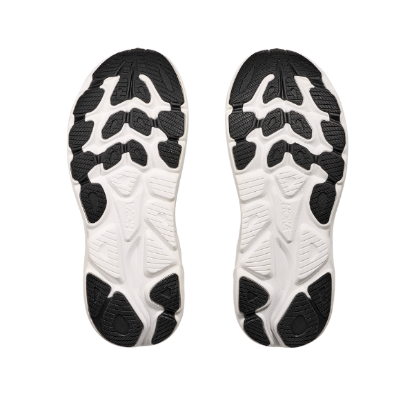 Two HOKA Mens Clifton 10 Black/White running shoe soles, shown from above, display cushioned styles with black and white rubber, geometric patterns, and textured grips.