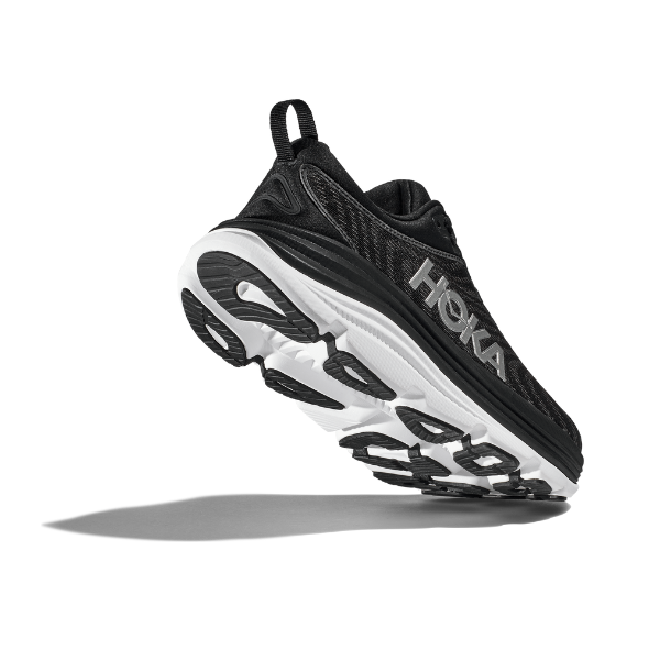 The HOKA Mens Gaviota 5 Wide in Black/White is angled against a white background, emphasizing its Stabilizing H-Frame, thick cushioned sole, tread design, and creel jacquard mesh upper.