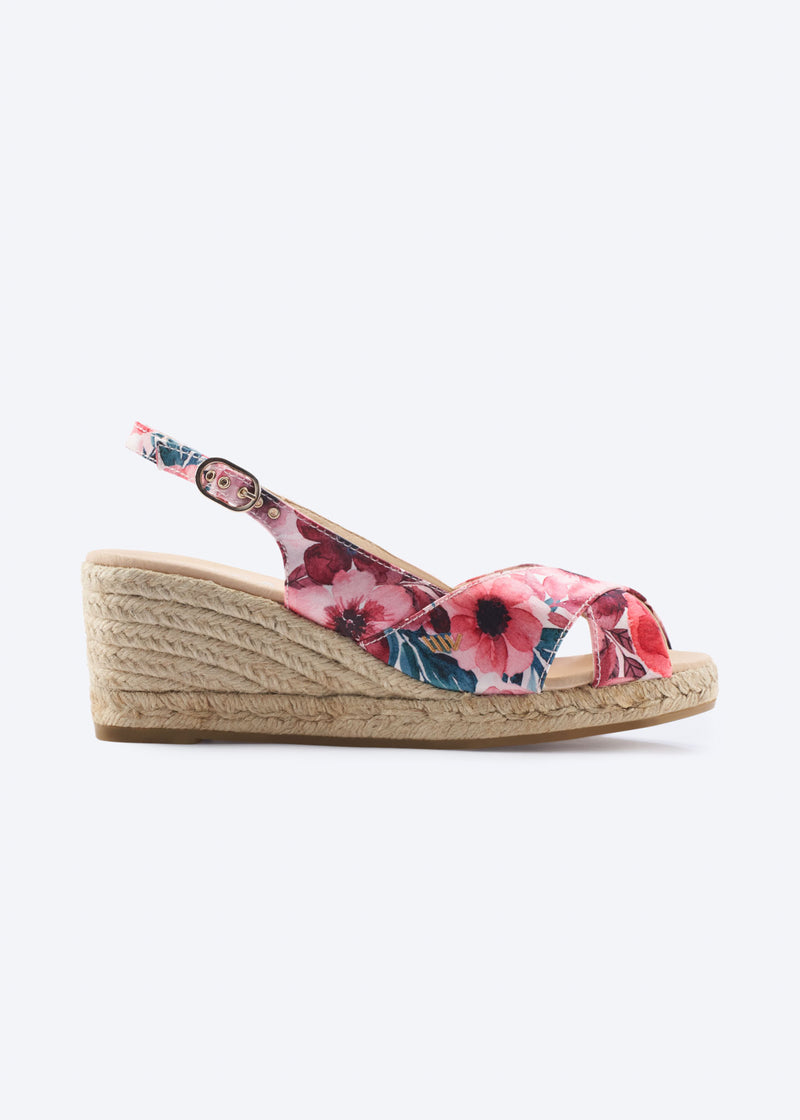 Side view of floral print wedge espadrille sandal with crossover front straps, slingback strap, and natural braided jute wedge, handcrafted in Spain