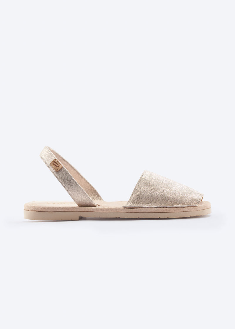 Side view of a women’s metallic leather espadrille sandal with slingback strap and cushioned flat sole, handcrafted in Spain.