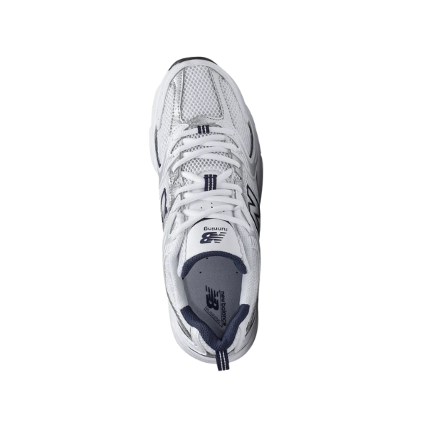 Top view of a white New Balance Unisex 530 sneaker with grey accents, mesh upper, and NEW BALANCE branding on the tongue, designed for comfort, set against a plain white background.