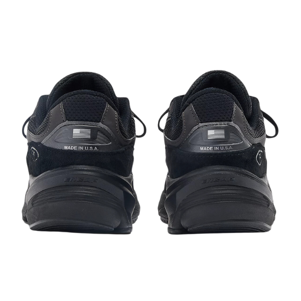 A pair of New Balance Mens 990v6 Black sneakers viewed from the back, featuring MADE IN U.S.A. text and an American flag on each heel, plus visible FuelCell midsole cushioning and detailed soles.