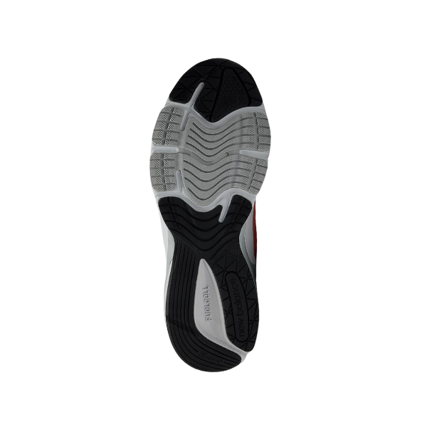 The image shows the sole of the NEW BALANCE Unisex 990v6 Rose running shoe. The mostly black and gray tread has textured grooves for traction and is designed to help relieve foot pain.