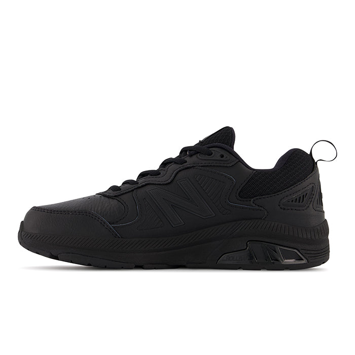 The New Balance Womens WX857 V3 Wide Black training shoe features a textured sole, mesh upper, lace-up front, side NEW BALANCE logo, and advanced ROLLBAR technology, shown in side view on a white background.