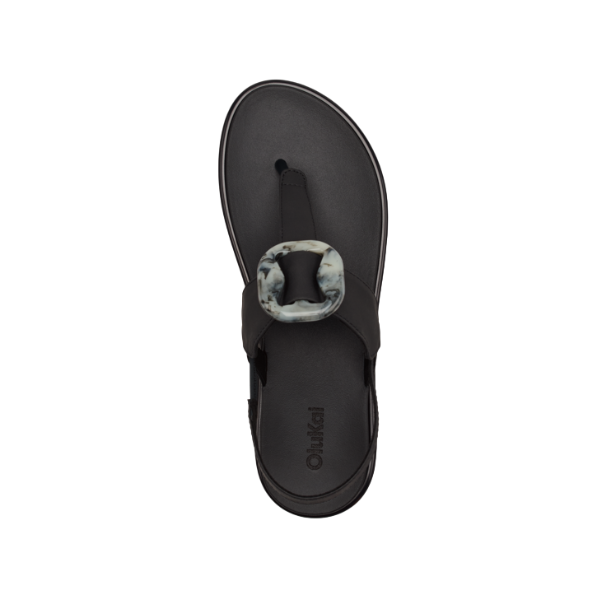 Top view of the OLUKAI Womens La‘i T–Bar Lava Rock sandal with a comfy thong-style T-Bar strap, large marbled buckle, and OLUKAI branding on the footbed; ideal plantar fasciitis footwear.