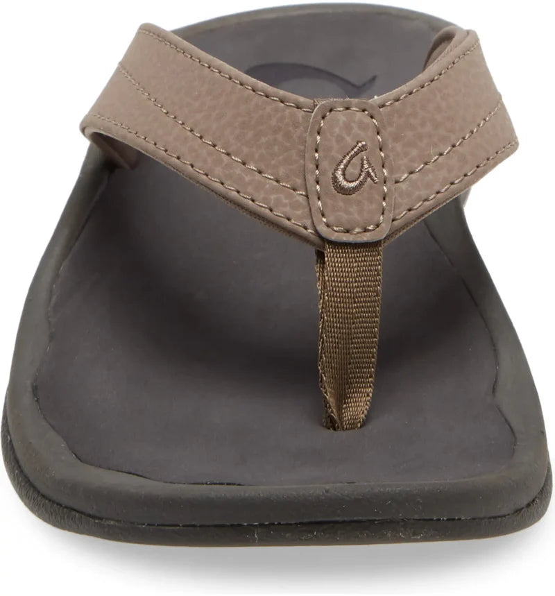 Front view of the OLUKAI Womens Ohana Taupe sandal, featuring a Wide textured strap with visible stitching, a center loop, and a black curved sole with an anatomical footbed for enhanced comfort.