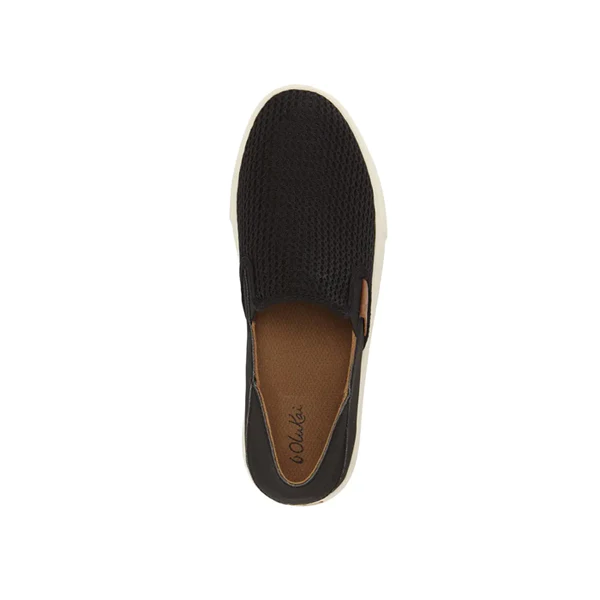 Top view of the OluKai Womens Pehuea Black slip-on by OluKai, featuring a white sole, brown insole, textured black mesh upper, Drop-In Heel®, and a stylish small leather accent on the side for added convenience.