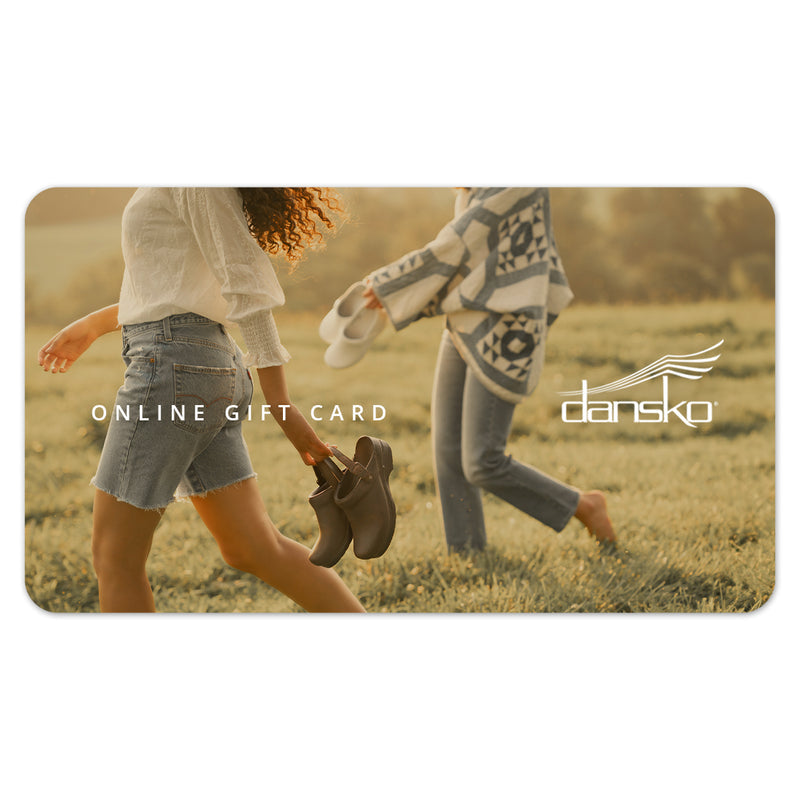 Gift card with a background image of two girls walking through a field holding their Dansko shoes, with the overlay text reading "Online Gift Card". The Dansko logo is overlaid on the right hand side.