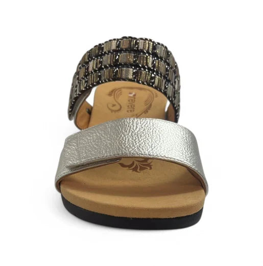 Front view of the REVERE Revere Womens Sorrento Silver sandal, featuring a metallic silver toe strap, black and gold beaded ankle strap, tan footbed, and black sole designed for comfort.