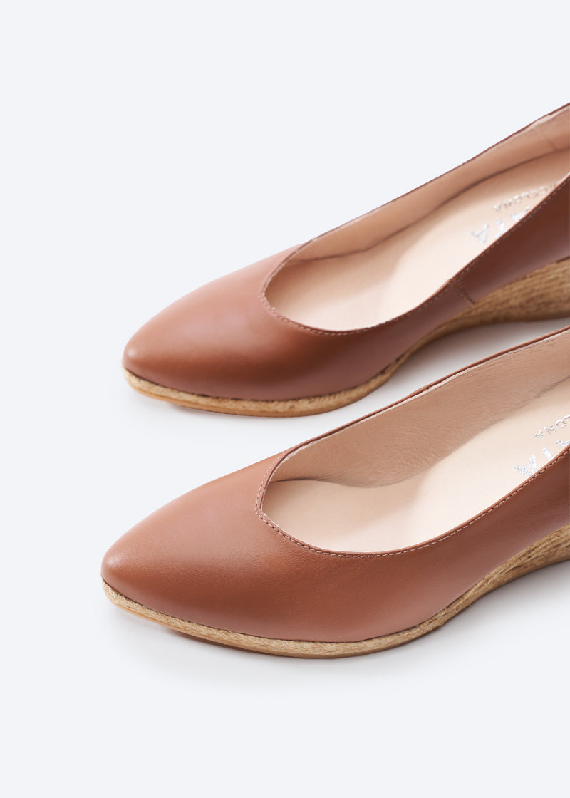 Pair of brown leather espadrille wedge pumps, close-up.