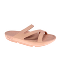 The Sovella Womens PF Slide Pink is a light pink open-toe sandal by SOVELLA, with three Wide straps, a textured footbed with arch support and rebound tech for all-day comfort, a slightly raised sole, and embossed branding on the side.