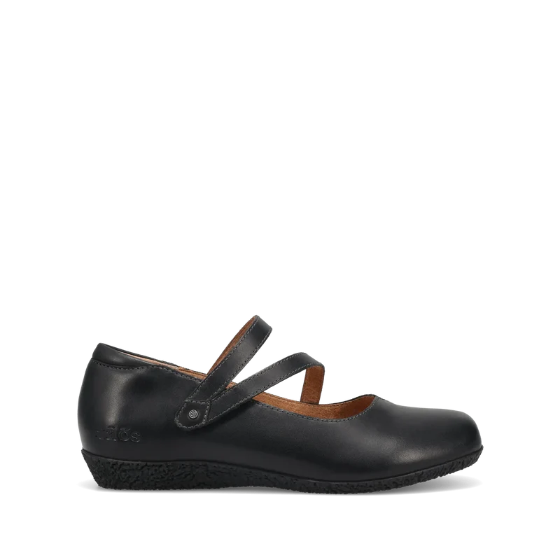 The TAOS Taos Womens Banter Black is a chic luxe leather Mary Jane flat with a low wedge heel, two crossing straps, arch and metatarsal support, plus a removable footbed for all-day comfort. Shown in profile against a white background.