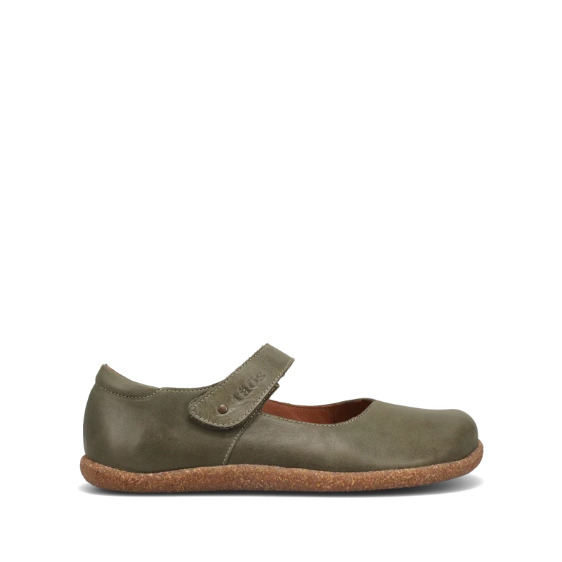 The TAOS Women's Ultimate Leather Mary Jane Forest is a single olive green flat with a rounded toe, Velcro strap, and textured brown sole, offering gentle arch support. Displayed on a plain white background.