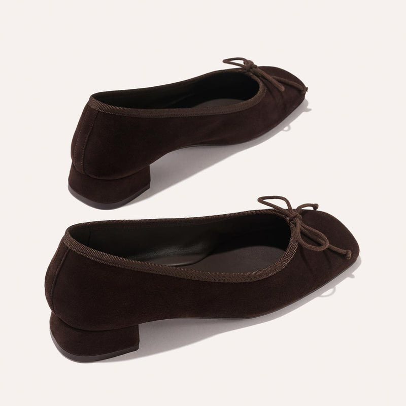 The Ada - Espresso Suede by margaux-development: dark brown suede low-heeled ballet pumps with small bows on rounded toes and a glove-like fit from sacchetto construction, displayed on a light background.