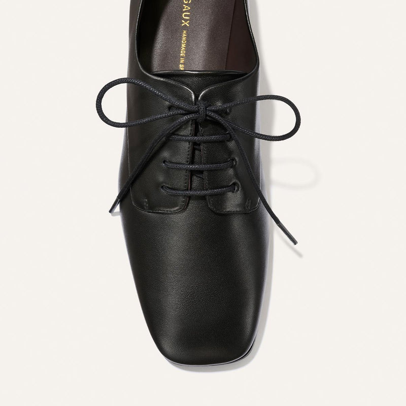 The Billie Derby - Black Nappa by Margaux, a black leather lace-up dress shoe with a square toe, is shown from above on a light background.