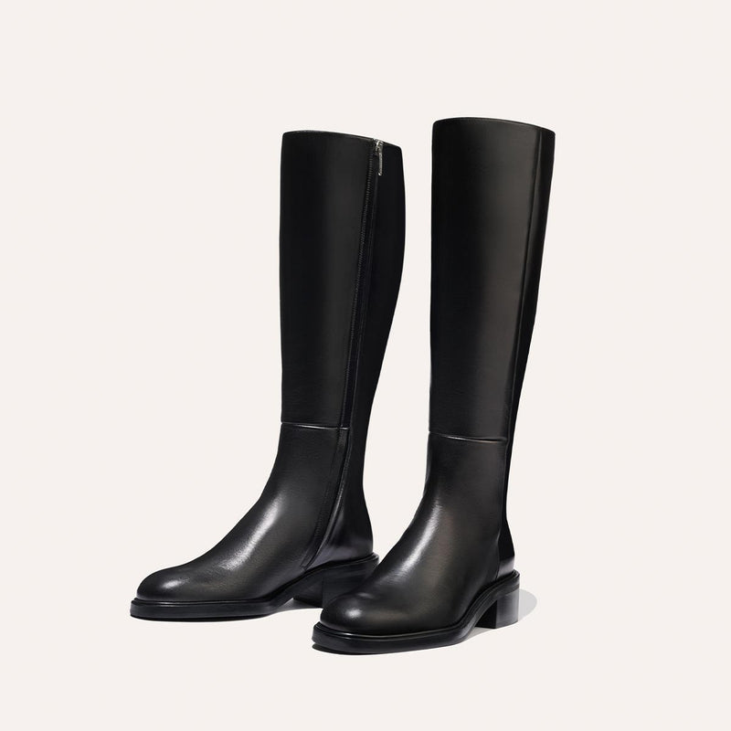 The City Boot - Black Calf by Margaux: sleek black riding boots with a classic silhouette, low heels, and side zippers, shown against a simple light background.