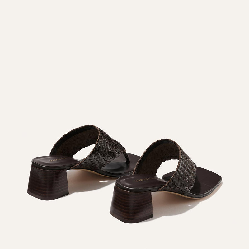 Pair of brown woven sandals on a light beige background