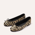 The Demi - Tan Zebra Haircalf by Margaux: comfortable ballet flats in black and beige zebra print with black trim and bow, handmade in Spain, shown on a light background.