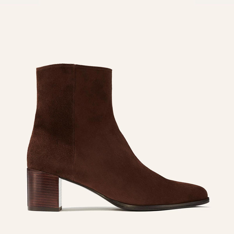 Margaux’s The Downtown Boot First Edition in Chocolate Suede is a western-inspired ankle boot with a slightly rounded toe and mid-height stacked heel, shown in a side profile against a light background.