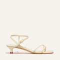 Cream colored sandal with thin straps on a white background