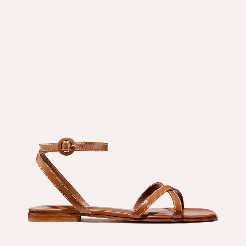 The Flat Sandal in saddle brown nappa, a minimal sandal featuring thin, flattering straps with a subtly square toe.