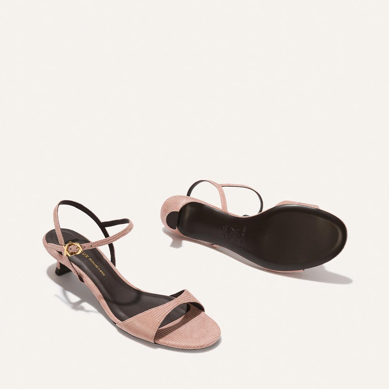 Pair of pink high-heeled sandals on a white background
