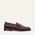 The Marlowe Loafer - Burgundy Calf by margaux-development is shown in a side profile, displaying burgundy leather, a low heel, and stitching detail against a plain light background.