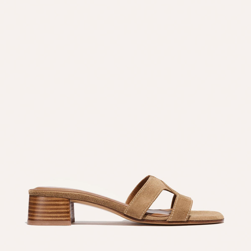 The MX 35 - Biscotti Suede by Margaux features a tan suede slide design with wide double straps and a medium stacked block heel, showcased on a simple light background.