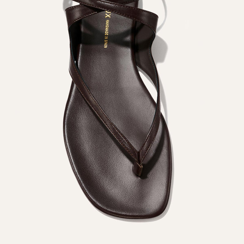 Brown sandal with a thin strap on a light gray background