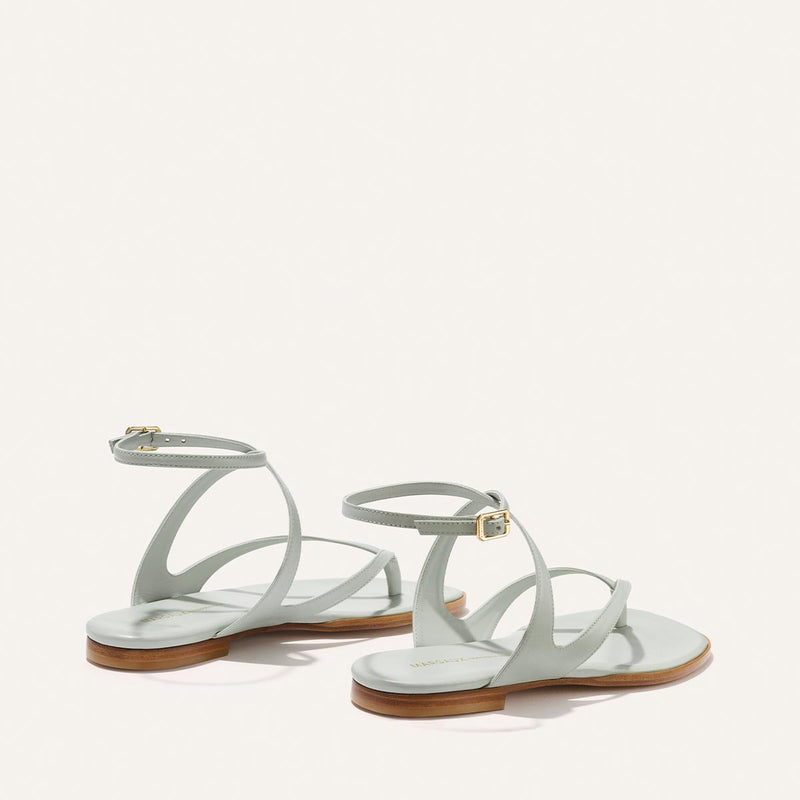 Pair of light blue sandals with wooden soles on a white background