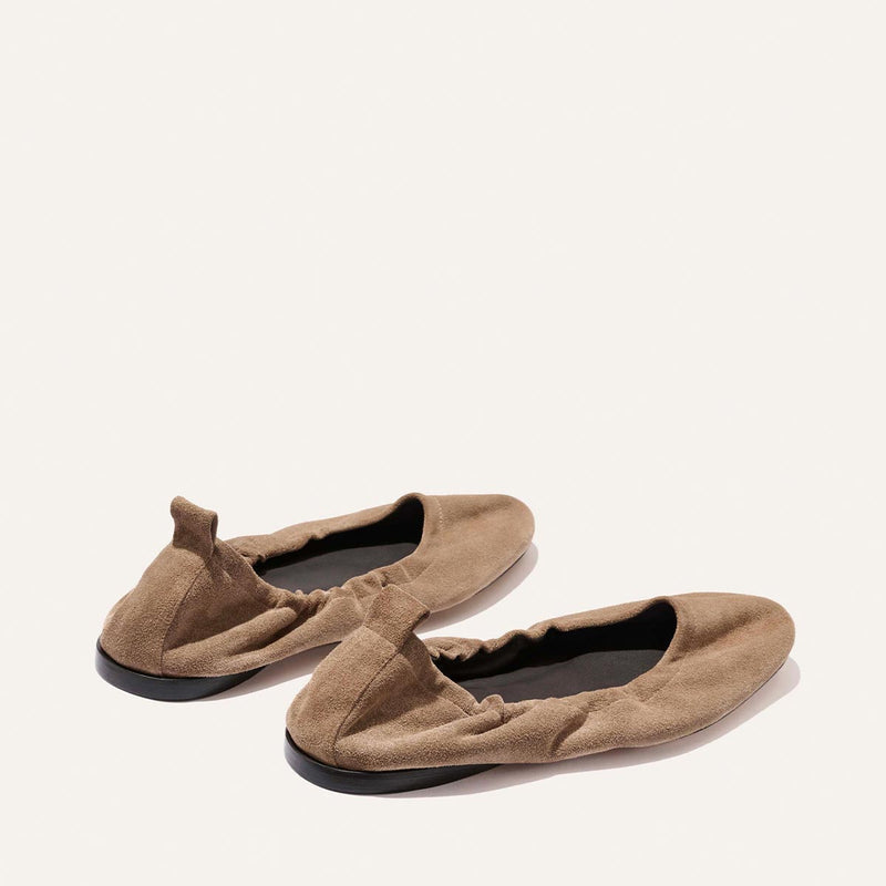 The Pascale - Cappuccino Suede ballet flats by Margaux feature tan suede, elasticated backs, and black soles, shown side by side on a plain light background.
