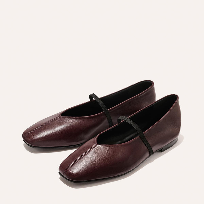 The Phoebe - Burgundy Nappa by margaux-development: burgundy leather ballet flats with squared toes and a thin black strap, crafted in sacchetto construction for the softest feel, displayed on a light background.