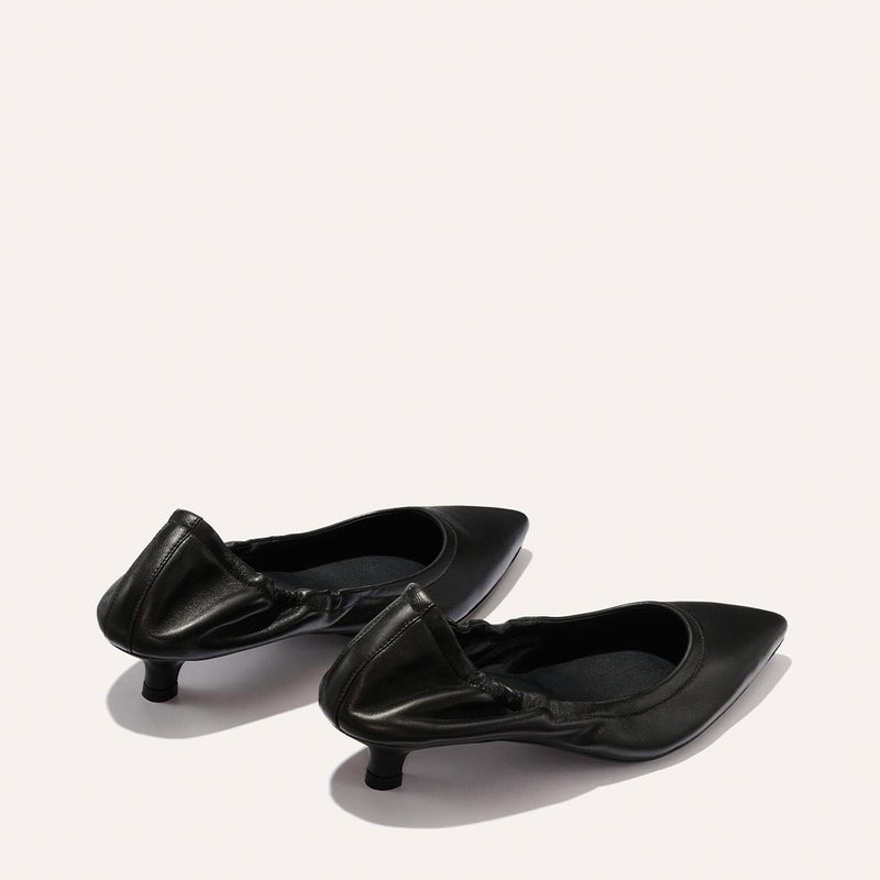 The Roma 40 - Black Nappa by Margaux: a pair of black chic kitten heels with ruched back detailing, displayed on a light background and positioned slightly apart.