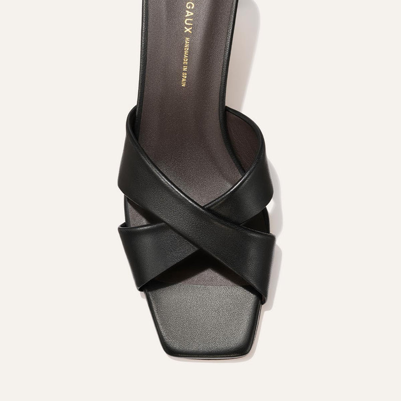 Black sandal with criss-cross straps on a white background