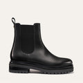 The West Chelsea Boot - Black Calf by margaux-development features black leather, elastic side panels, a back pull tab, and a thick lug sole, shown on a plain light background.