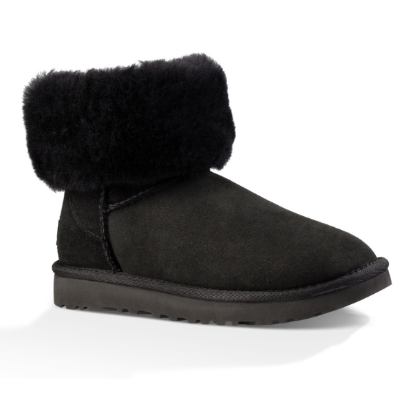 The UGG Womens Classic Short II Boot in black suede features a cozy, folded faux fur cuff and flat textured sole, offering classic sheepskin-inspired style and comfort for your feet.