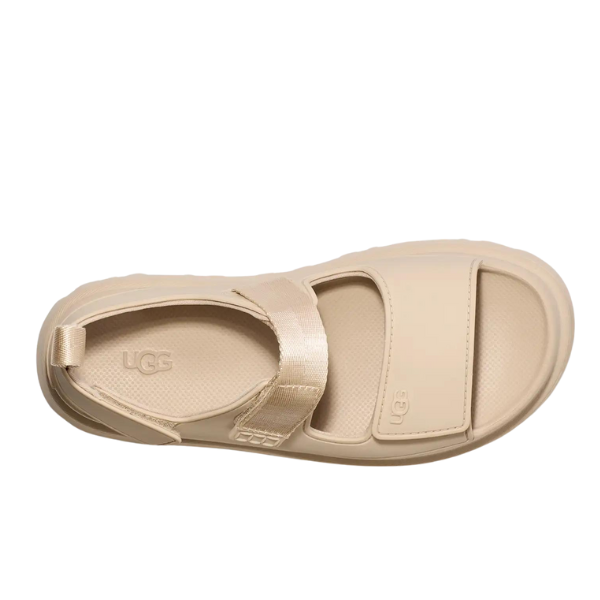 The UGG Womens Goldenglow Sandal in beige features a closed heel strap, Wide adjustable front strap, and open toe. This stylish platform sandal offers comfort and support for everyday wear. Shown from above on a white background.